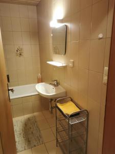Ferienwohnung Seidl Top 2 في راوريس: حمام مع حوض وحوض ومرآة