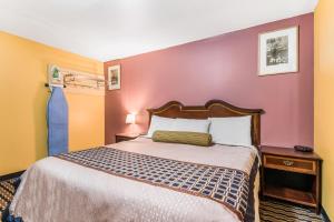 Habitación de hotel con cama y pared púrpura en Cottage Inn - Grantville, en Grantville