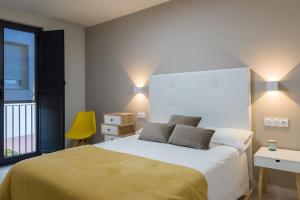 a bedroom with a large bed and a yellow chair at O balcón da ribeira in Parada del Sil