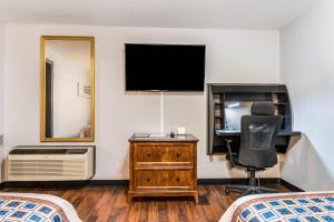 a bedroom with a desk and a television and a chair at Cottage Inn - Grantville in Grantville