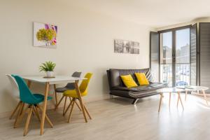 a living room with a table and chairs and a couch at O balcón da ribeira in Parada del Sil