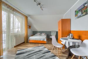 a bedroom with a bed and a table and chairs at Willa U Artura in Tylicz