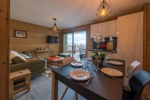 a kitchen and living room with a table and chairs at ODYSSEE ERJ01 Appartement avec terrasse et acces aux pistes in La Toussuire