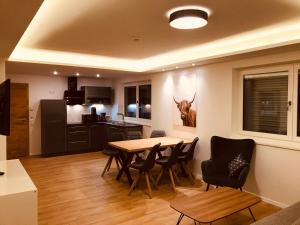 a kitchen and dining room with a table and chairs at Apartment Mitterberger - Nassfeld in Tröpolach