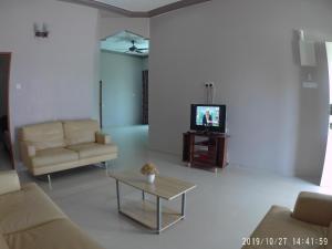 a living room with a couch and a tv at Oriental Homestay Dungun in Dungun