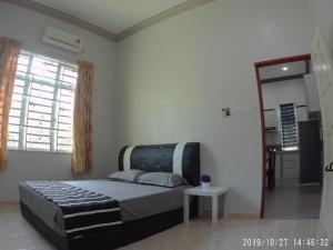 a bedroom with a bed and a window and a table at Oriental Homestay Dungun in Dungun
