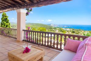 聖約瑟夫沙塔萊亞的住宿－Villa Cas Berris，阳台配有沙发和带酒杯的桌子。