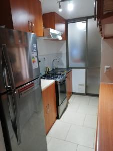 eine Küche mit einem Kühlschrank aus Edelstahl und einem Herd in der Unterkunft Dpto de playa 44 in Arica