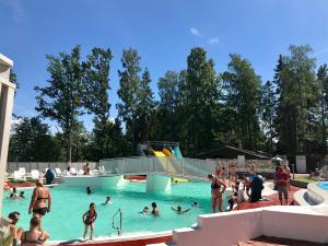 Eine Gruppe von Menschen im Wasser eines Schwimmbads in der Unterkunft Ursand Resort & Camping in Vänersborg