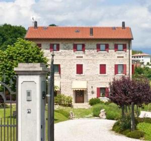 a large stone building with a red roof at Agriturismo Prime Gemme in Nervesa della Battaglia