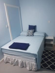 a blue bedroom with a bed with blue sheets and pillows at Careffe Suites Unit 4 in Cap Estate
