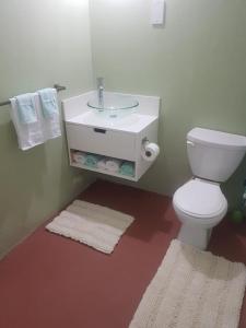 a bathroom with a toilet and a sink and towels at Careffe Suites Unit 4 in Cap Estate