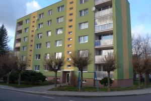 zielony i żółty budynek z drzewami przed nim w obiekcie Apartmán pod Smrkem w mieście Nové Město pod Smrkem
