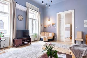 a living room with blue walls and a tv at Trendy Grand Boulevard Designer Home in Budapest