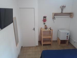 a room with a door and a table and a television at Pousada e Hostel Boneca de Pano in Maceió