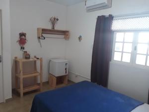 Pousada e Hostel Boneca de Pano في ماسيو: غرفة نوم بسرير ازرق ونافذة