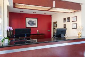 an office with a reception desk with a red wall at Studio City Courtyard Hotel in Los Angeles