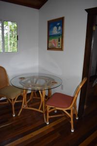 einen Glastisch mit zwei Stühlen, einem Tisch und zwei Gemälden in der Unterkunft Hidden Haven in Unitedville