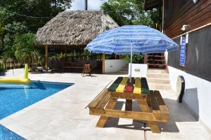 a picnic table with an umbrella next to a pool at Hidden Haven in Unitedville