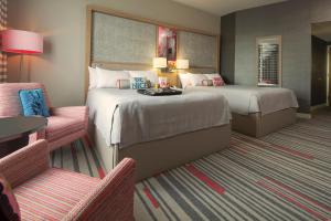 a hotel room with two beds and a chair at Universal's Hard Rock Hotel® in Orlando