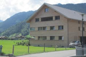 una grande casa in mattoni in un campo con idrante di Ferienwohnung Greber Regina a Bezau