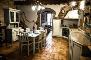 uma cozinha com uma mesa e cadeiras e um frigorífico em Casa Cristiano Bed & Breakfast em Piobbico