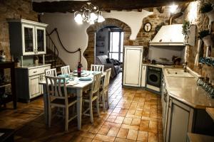 a kitchen with a table and chairs and a refrigerator at Casa Cristiano Bed & Breakfast in Piobbico