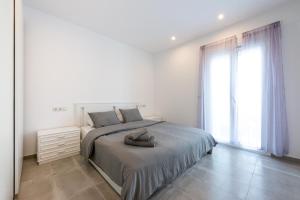 a white bedroom with a bed and a large window at Puerto Banus Frontline Apartment with Amazing Sea Views in Marbella