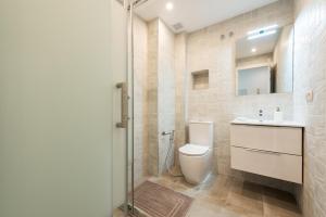 a bathroom with a toilet and a sink and a shower at Puerto Banus Frontline Apartment with Amazing Sea Views in Marbella +18 photos