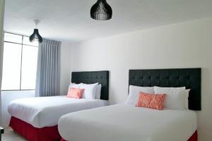 duas camas sentadas uma ao lado da outra num quarto em In & Out Hotel em Guatemala