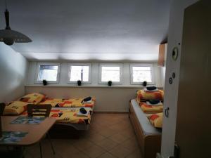Cette chambre comprend 2 lits, une table et des fenêtres. dans l'établissement Apartma David Rogla, à Zreče