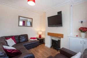 a living room with a couch and a flat screen tv at Silver Stag Properties, Charming 2 BR House in Leicester