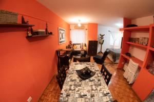 comedor con paredes de color naranja, mesa y sillas en Apart Mendoza Centrico, en Mendoza