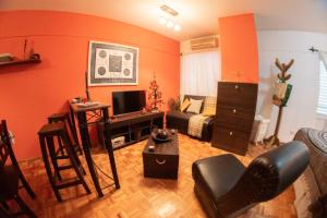 sala de estar con paredes de color naranja y sofá en Apart Mendoza Centrico, en Mendoza