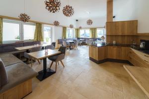 uma grande cozinha com armários de madeira, mesas e cadeiras em Harrauer´s Living em Erlauf
