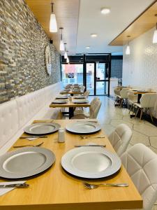 una mesa larga con platos blancos en un restaurante en Endamo Hotel, en Latacunga