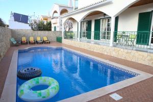 a swimming pool with a tire in front of a house at Casa Sousa in Lagos
