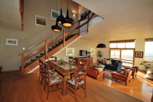 ein Wohnzimmer mit einem Esstisch und einer Treppe in der Unterkunft Villa Winglo in Rand Rifles