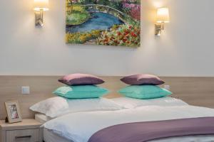 1 dormitorio con 1 cama con una pintura en la pared en Global Suites Budapest, en Budapest