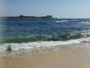 a couple of small waves on the beach at Cabaña tablaqui in El Quisco