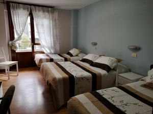 A bed or beds in a room at Hostal Campoamor