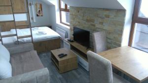 a living room with a fireplace and a table and chairs at Milmari, Resort, Premier Apartman A52 & Parking garage FREE in Kopaonik +47 photos