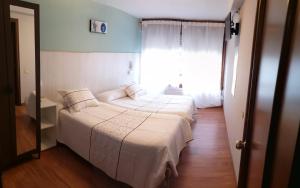 A bed or beds in a room at Hostal Campoamor