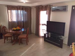 a living room with a table and a flat screen tv at Kalypso View Apartments in Letimbou