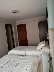 A bed or beds in a room at Hostal Campoamor