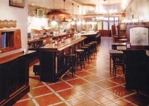 um restaurante com um bar com bancos de bar em Hostal El Jardín em Benidorm