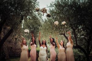 a group of women in white dresses throwing flowers in the air at Hotel La Badia di Orvieto in Orvieto