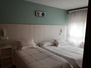 A bed or beds in a room at Hostal Campoamor