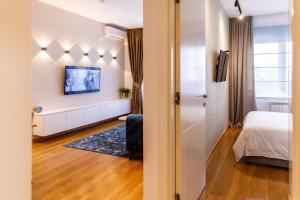 a small bedroom with a bed and a room with a window at Dali Apartments Pupin Palace in Novi Sad