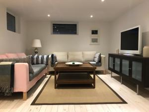 a living room with a couch and a tv at Country House by the lake in Hästveda